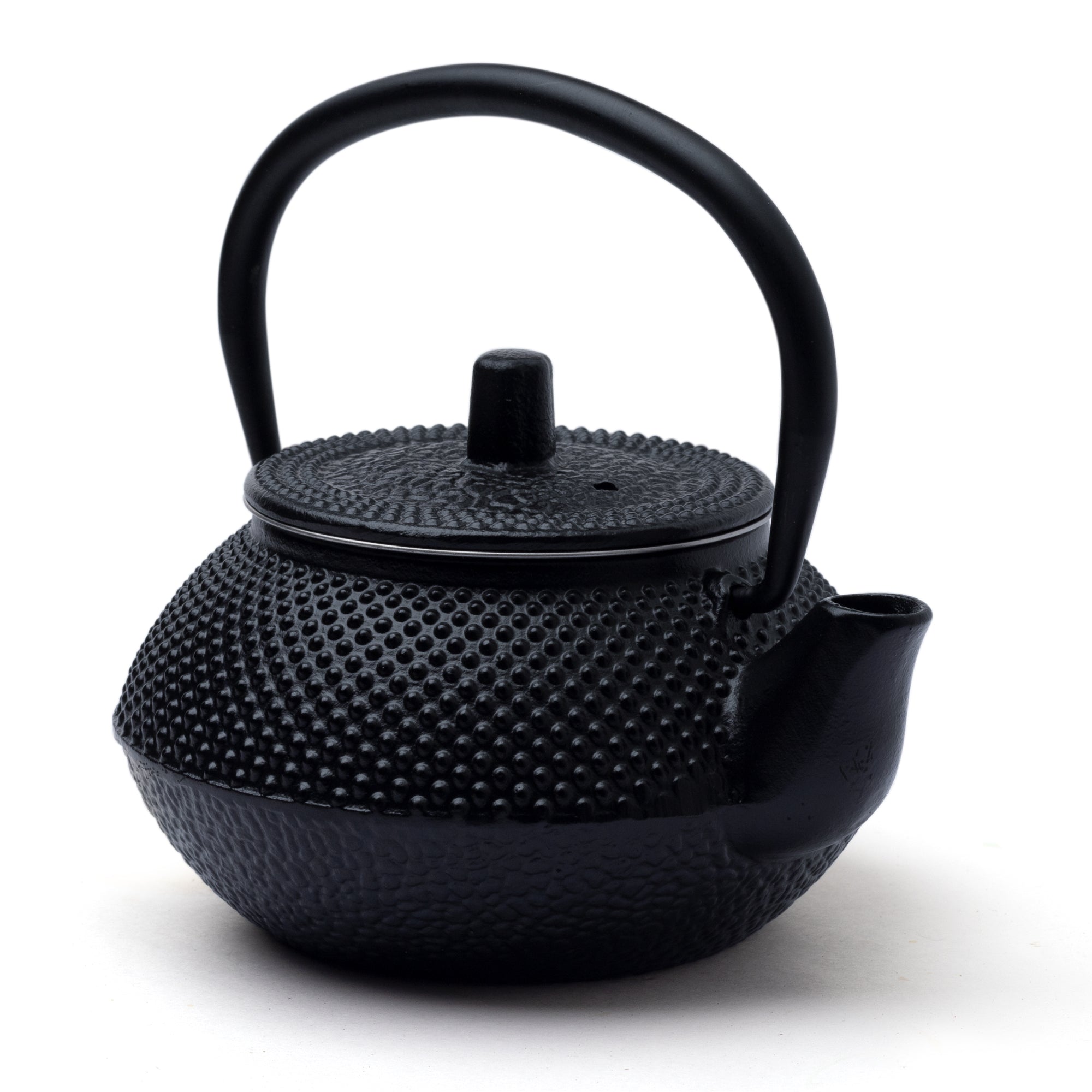 A black cast iron teapot with a textured surface and a rounded handle.